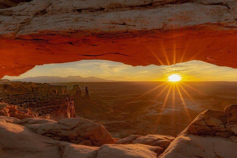 Mesa Arch Canyonlands National Park Incredible Sunrise over canyon with red glowing arch similar to arches national park Utah on a one day itinerary