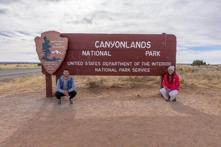 Mark and Kristen Where Are Those Morgans kneeling in front of canyonlands national park entrance sign