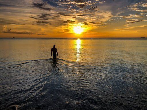 Travel Wellness mark in Thailand Koh Lanta beach sunset