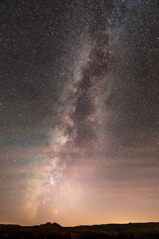 Milky Way bursting out of clouds and sunset