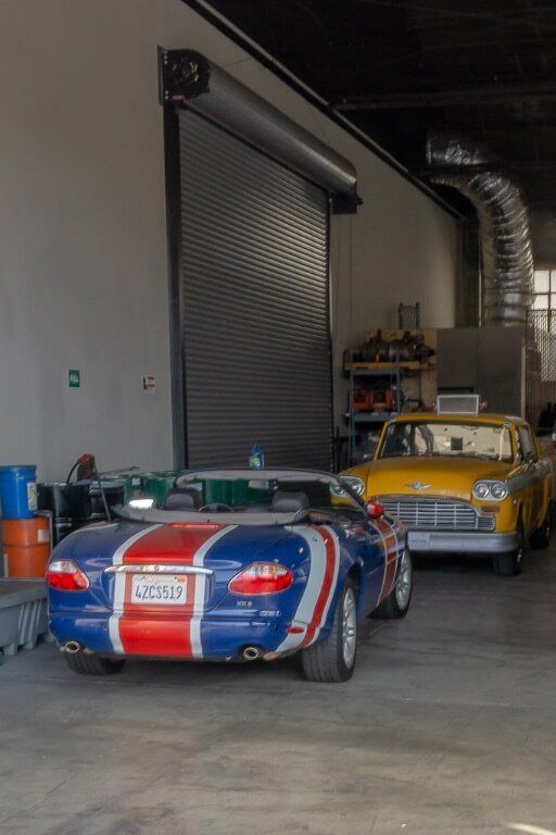 Austin powers car and phoebe's taxi from friends in garage on movie studio lot