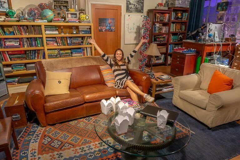 Kristen sitting on sofa of Big Bang theory apartment set