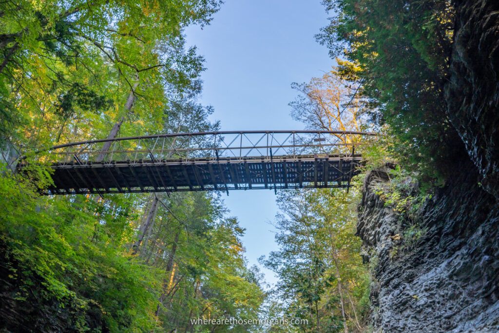 Suspension bridge crossing between two rock cliffs with colorful leaves