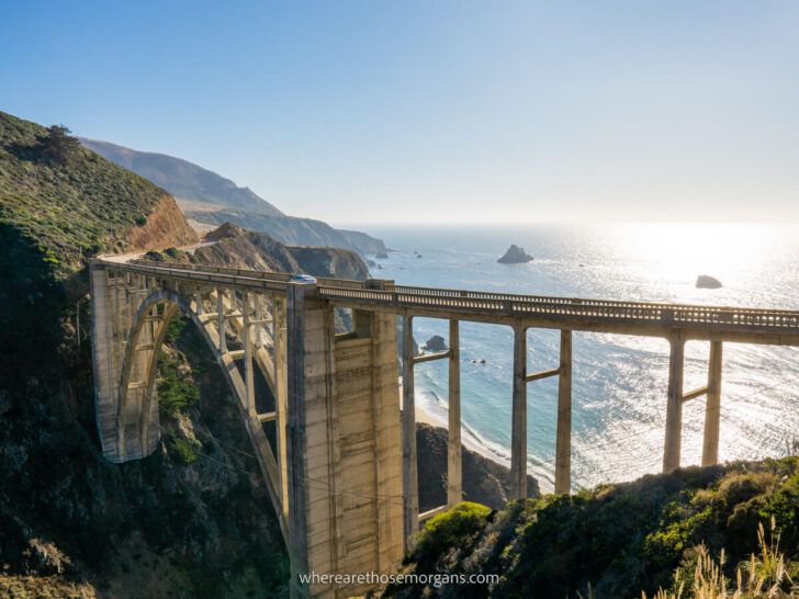 Bixby Bridge is one of the most popular attractions along the California Pacific Coast Highway 1 road trip from San Francisco to San Diego beautiful bridge with Pacific Ocean backdrop and sun reflecting