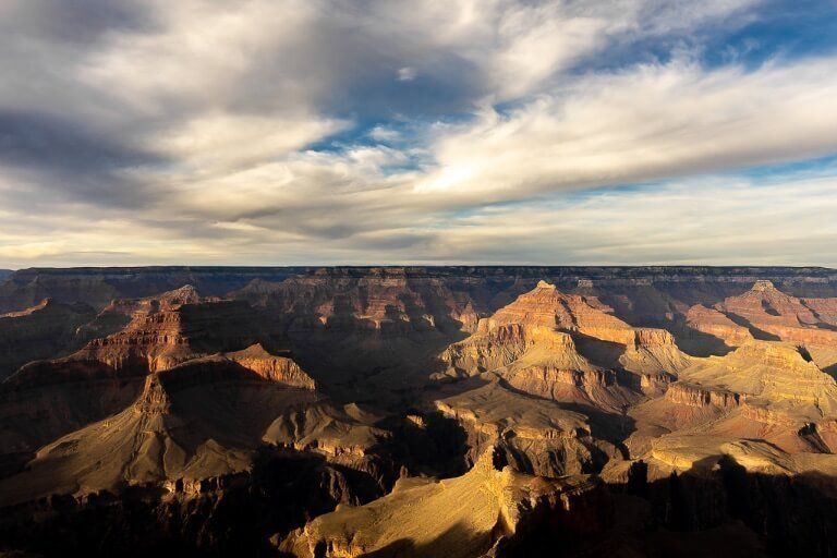 Just before sunset at Mohave Point Grand Canyon South Rim gorgeous yellow hue and deep dark shadows cast in the canyon epic one day itinerary