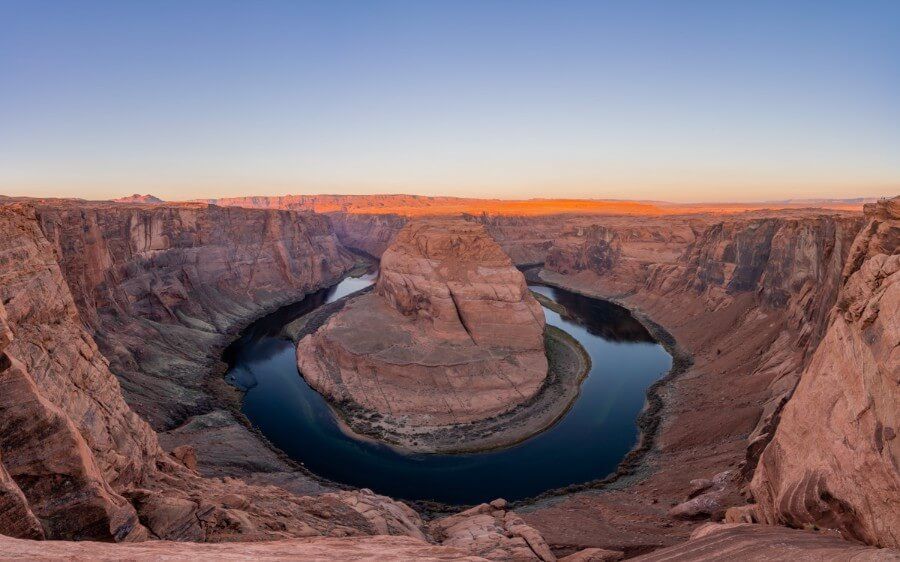 Wide angle panoramic vista of Horseshoe Bend in Arizona at sunrise stunning colors lighting up formations