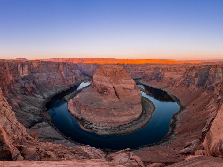 Stunning sunrise over Horseshoe Bend in Page Arizona purple sky and orange sandstone rocks being lit up by the morning sun horseshoe shaped bend in the Colorado River is immense