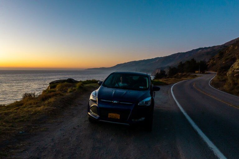 Our car parked on the side of California Pacific Coast highway 1 at sunset