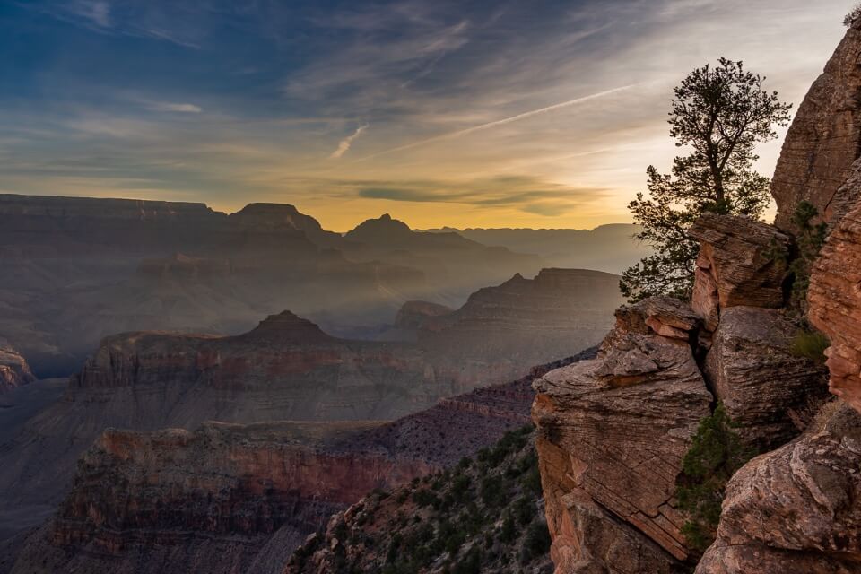 Stunning sun beams bursting into grand canyon south rim at sunrise on south kaibab trail amazing photography