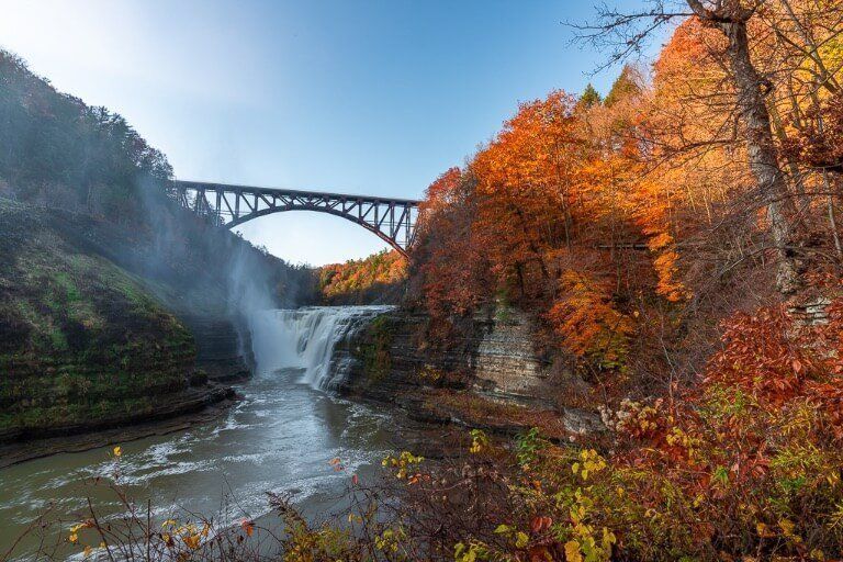 Letchworth State Park Upper Falls in autumn with stunning fall foliage blue sky and awesome waterfall