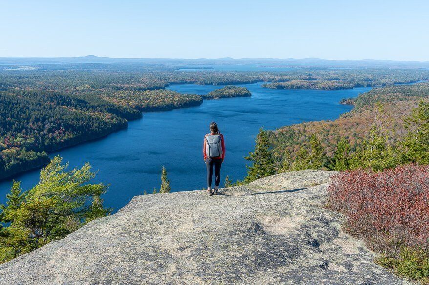 Kristen on a summit in Acadia National Park overlooking a huge lake with misty sky