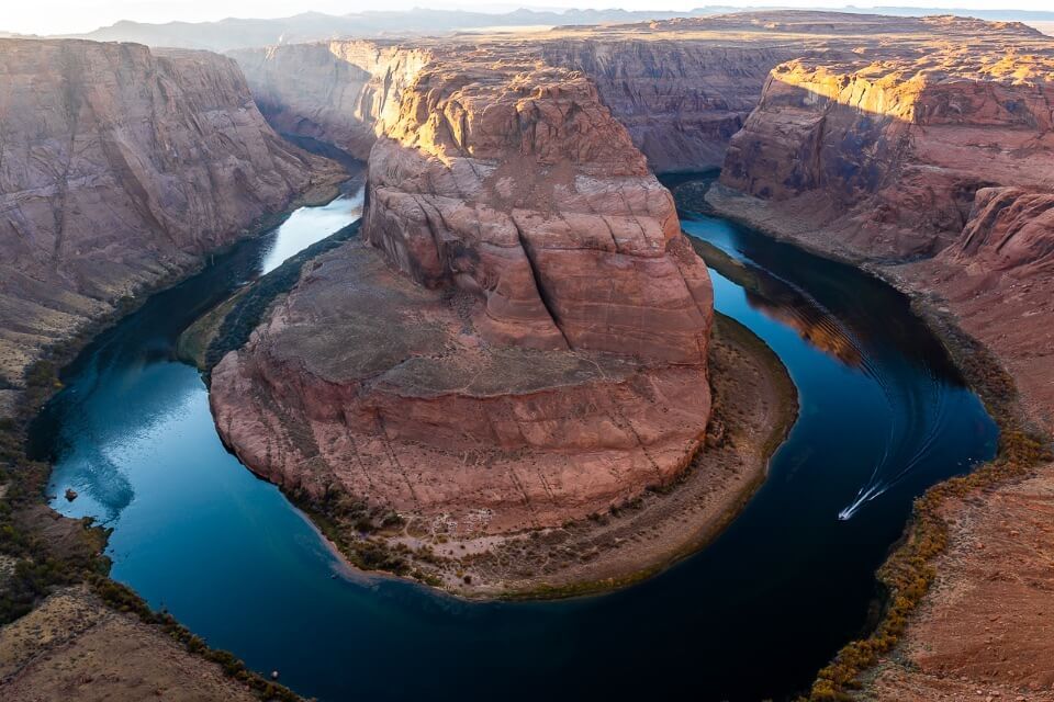 Horseshoe Bend in Page Arizona before sunset with speedboat turning bend