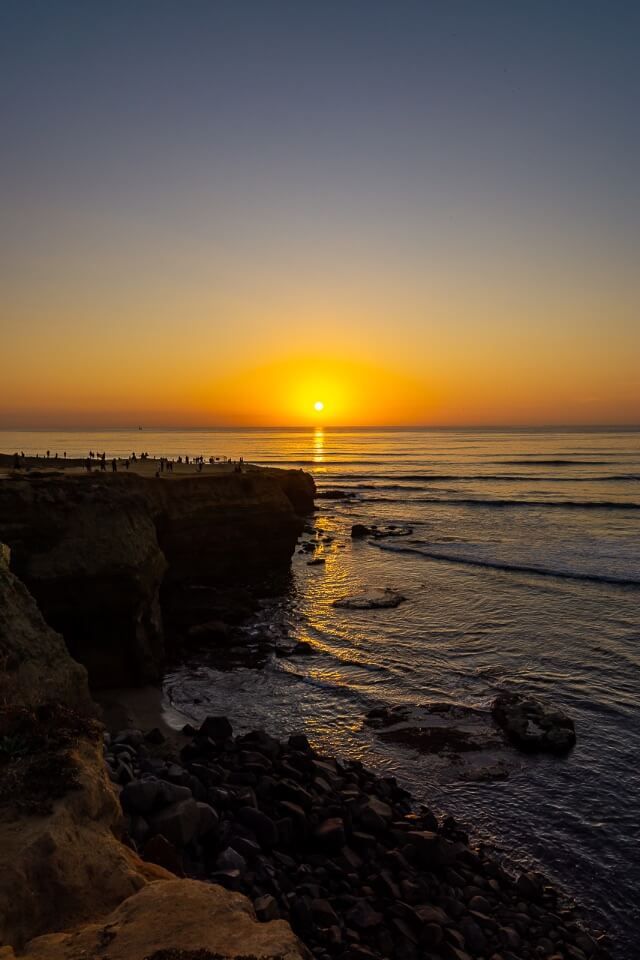 Stunning California sunset at sunset cliffs in san diego sunlight reflecting on pacific ocean and clear purple sky