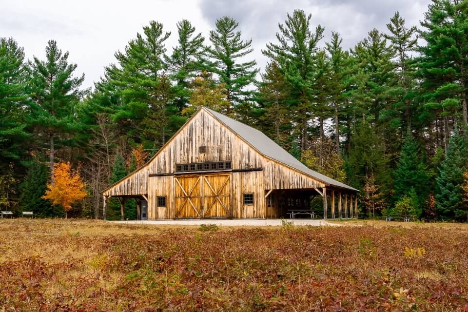 Stunning wooden barn backed by green trees along kancamagus highway scenic drive in new hampshire usa
