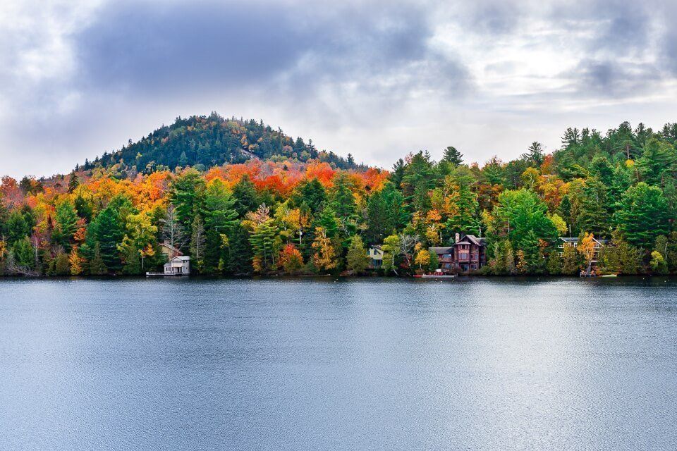 Mirror Lake in Lake Placid New York stunning colors in fall and blue grey lake with dense clouds
