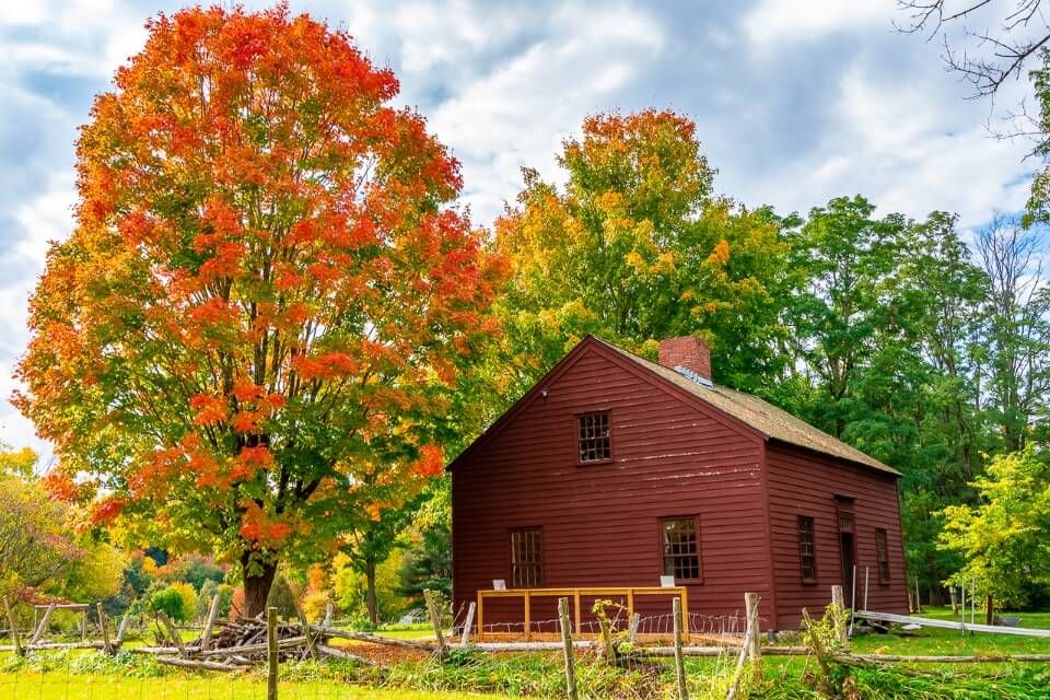 Gorgeous wooden barn with amazing fall foliage colors greens reds vermont photography