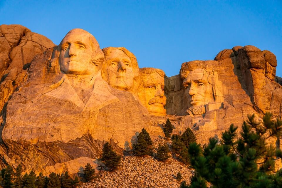 Mount Rushmore turning brilliant orange as the low sun lights up one of the most iconic pictures of all in america