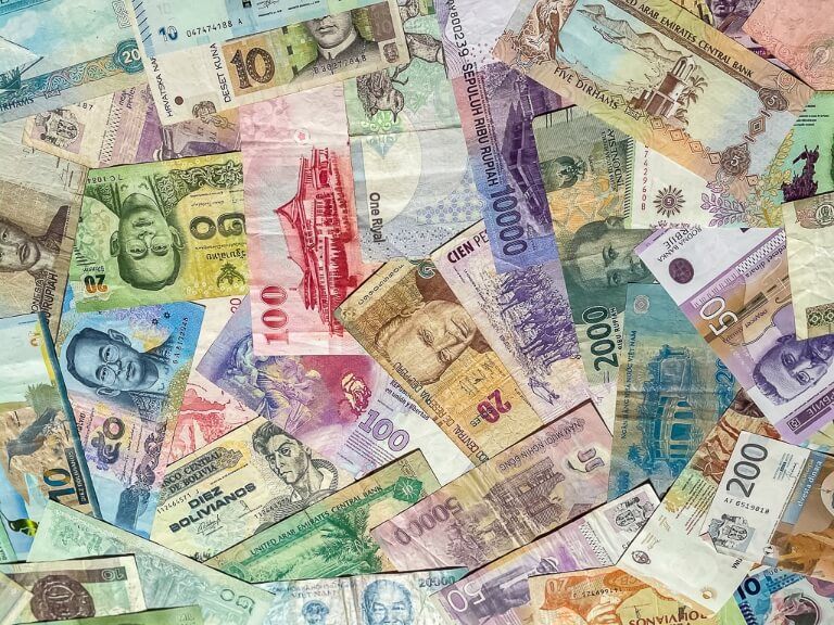 Money currency from around the world - it is difficult to save for travel and a long trip