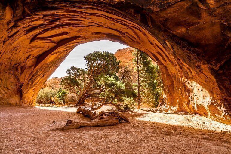 Stunning tunnel like rock formation illuminated orange Navajo in Utah