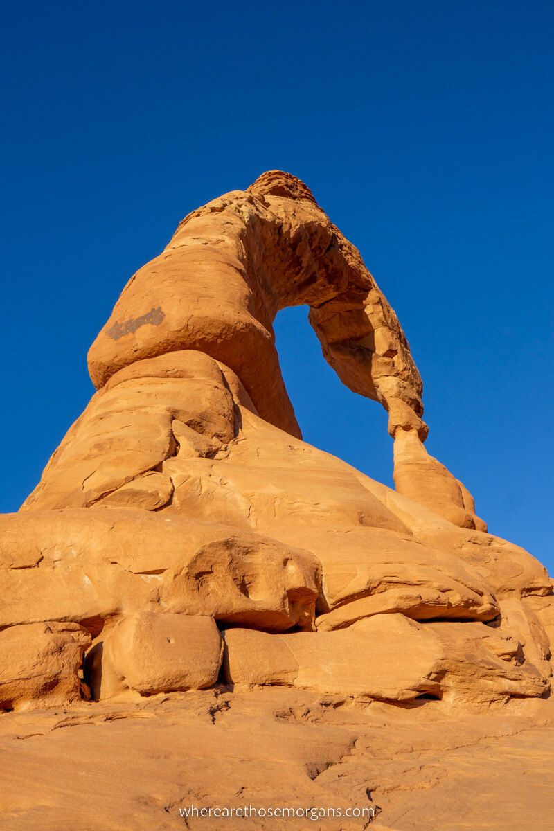 Delicate Arch in Arches national park from below at dusk with deep blue sky