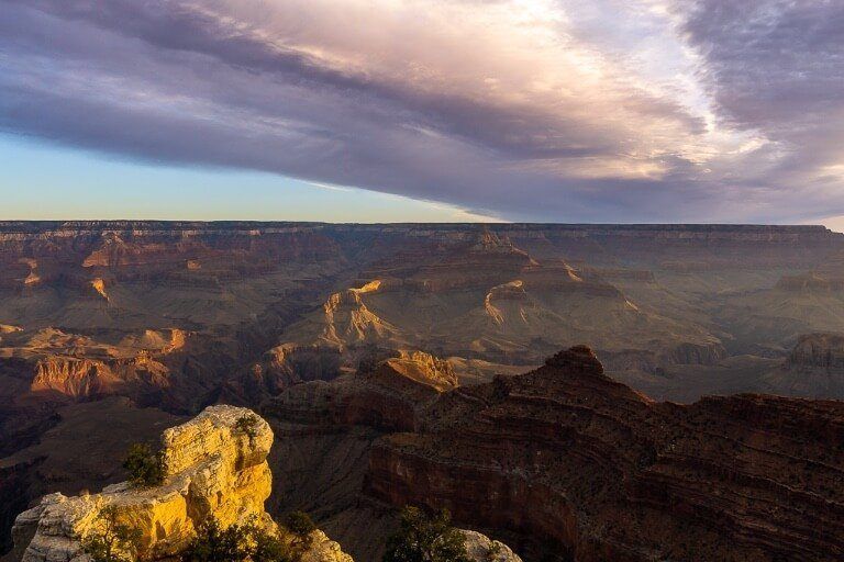 Stunning sunrise at the Grand Canyon South Rim as beams of light penetrate the canyon and light up the cliffs