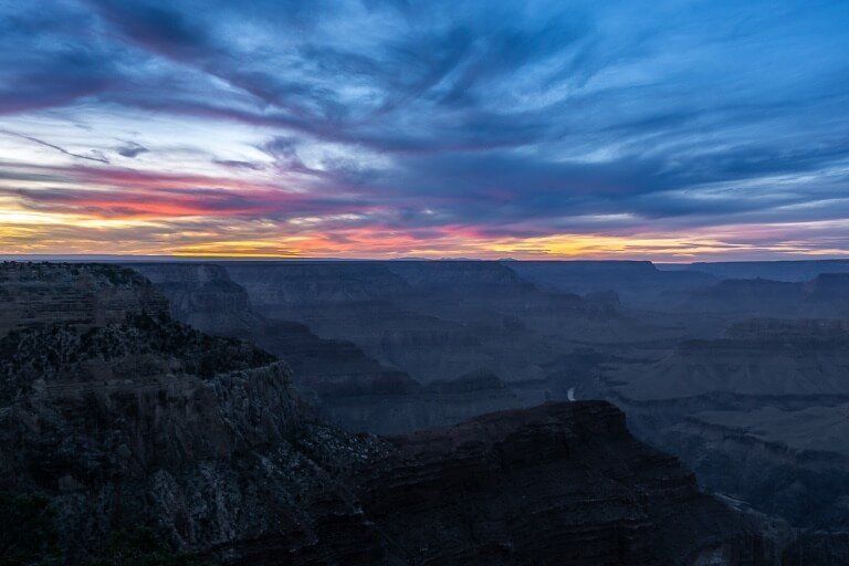 Sunset at Hopi Point in grand canyon south rim bright colors in sky turning to blue at dusk