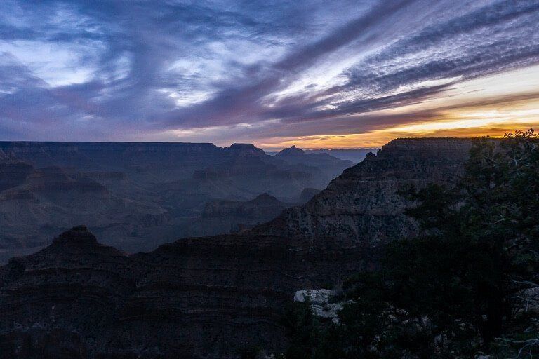 Mather Point at dawn orange sun lighting the clouds up beautiful purples in Arizona