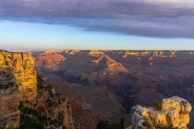 Mather Point from the Rim as the sun is rising and lighting up the canyon floor with clouds turning purple