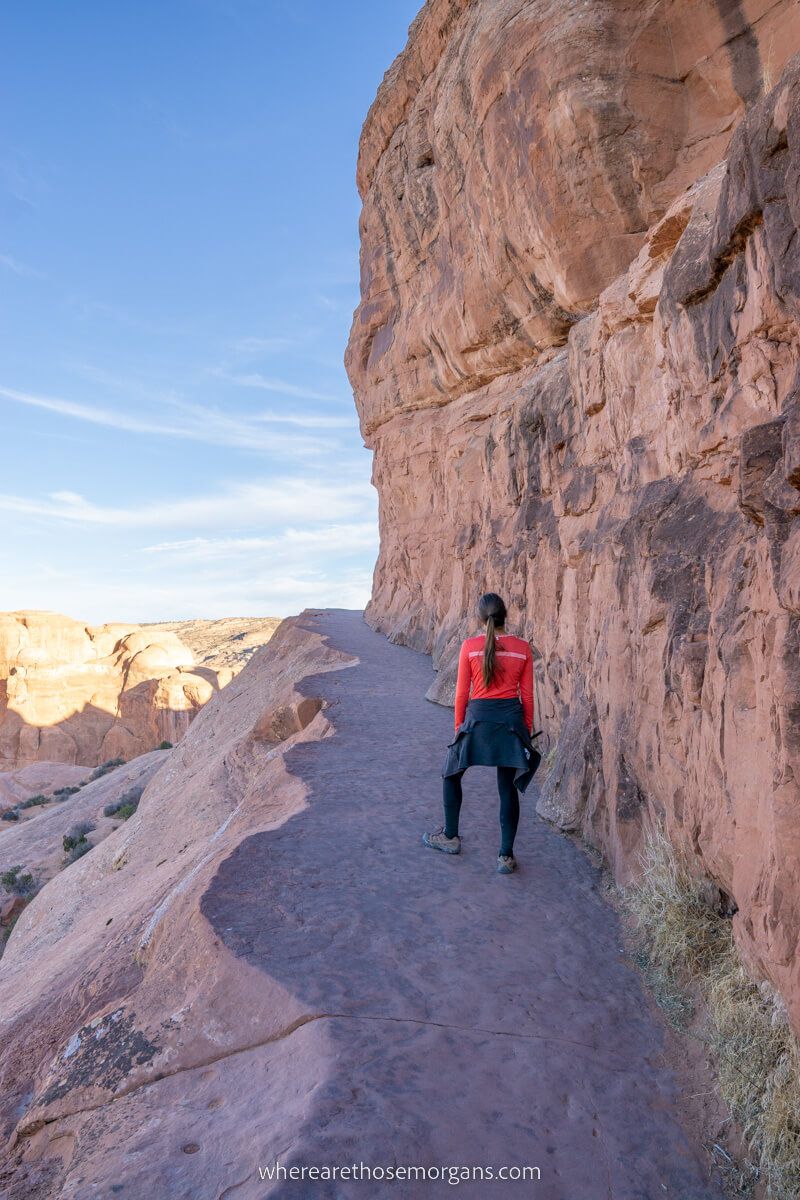 Hiker on a narrow path leading up to a summit in Utah