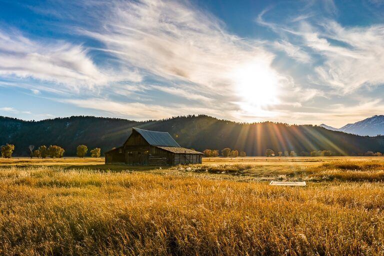 TA Moulton barn sunset mormon row grand teton national park starburst gorgeous field and blue sky