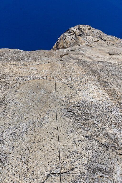 El Capitan climbing wall from directly at the bottom with a rope and climber in the top left of the picture