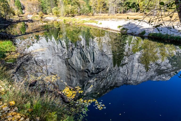Perfect reflection photograph of granite dome in deep blue river yosemite national park photography