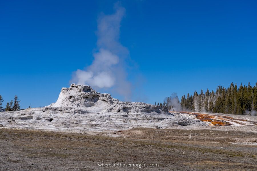 Rocky geyser in upper basin with small smoke stack