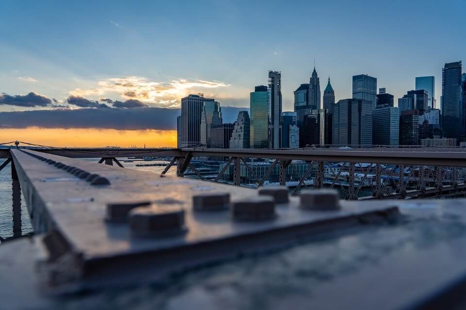Steel girder with bolts and manhattan skyline at sunset in NYC