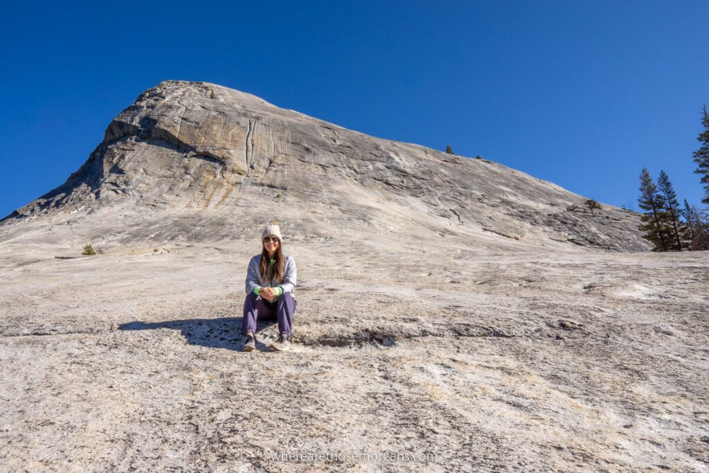 Hiker sat down on the steep face of Lembert Dome granite formation