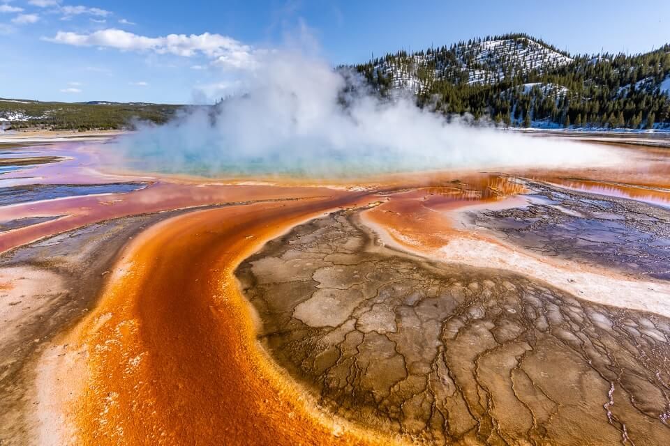 Grand Prismatic Spring vibrant colors steam billowing one of the focal points of a salt lake city to grand teton and yellowstone road trip