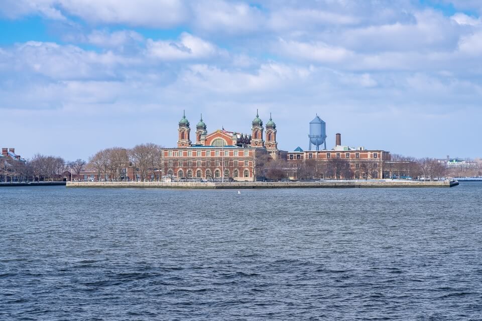 Ellis Island from afar on the river hudson huge building and water tower visible
