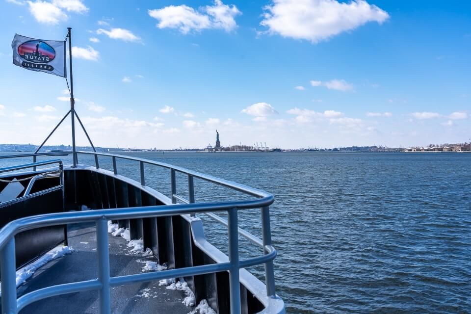 Boat on river heading towards island in new york city