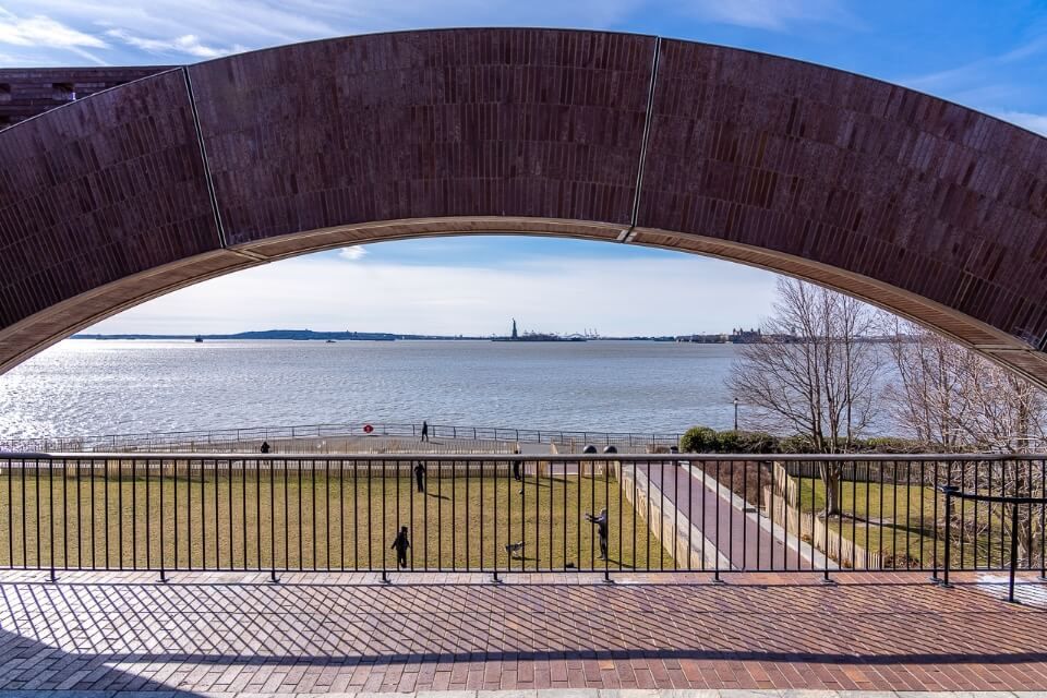 Statue of Liberty in distance as seen from Battery Park overlooking the hudson river