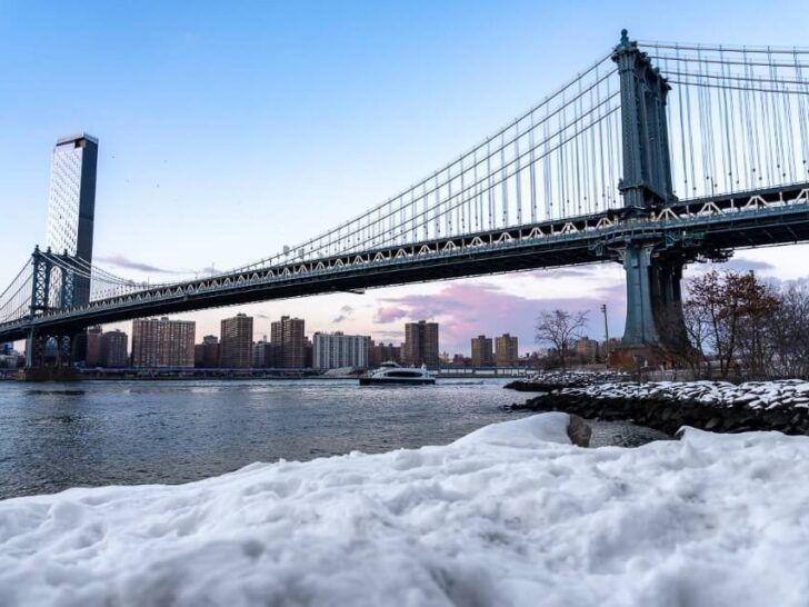NYC Manhattan Bridge with snow foreground taken from brooklyn pebble beach walk over the long bridge when visiting new york city