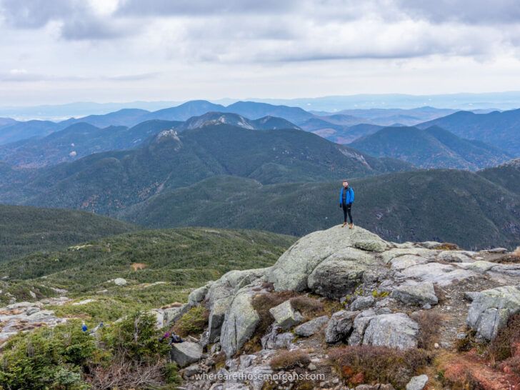 Man standing on distant rock for perspective to show to scale of views from the summit of mount marcy the highest of the high peaks in adirondacks new york near lake placid