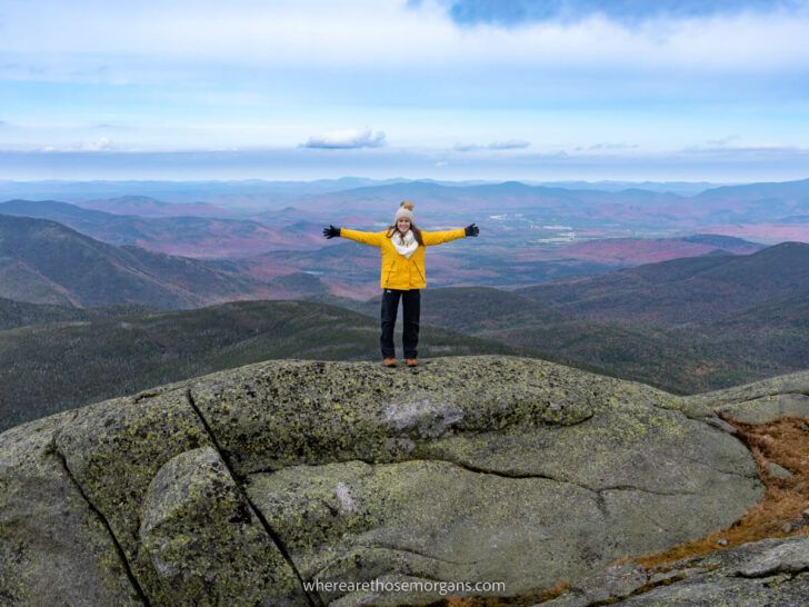Hiking Mount Marcy in the Adirondacks Mountains New York spectacular views from the summit with woman outstretched arms celebrating climbing the hike to reach the top of the highest high peak Where Are Those Morgans