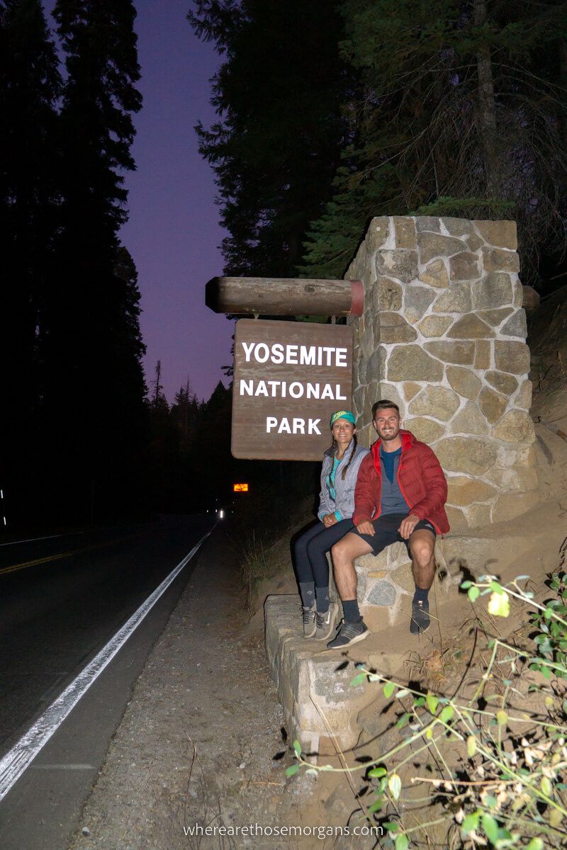 Mark and Kristen Morgan from Where Are Those Morgans at the Yosemite national park entrance sign at night