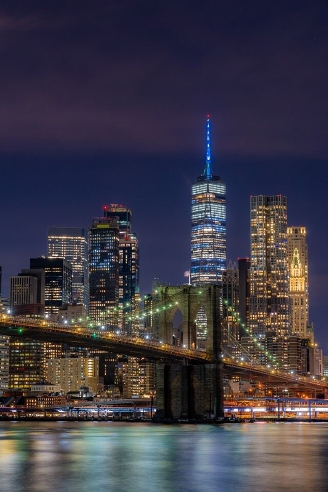 Manhattan skyline from Brooklyn with bridge foreground and one world trade center in background with blue spire new york city photography