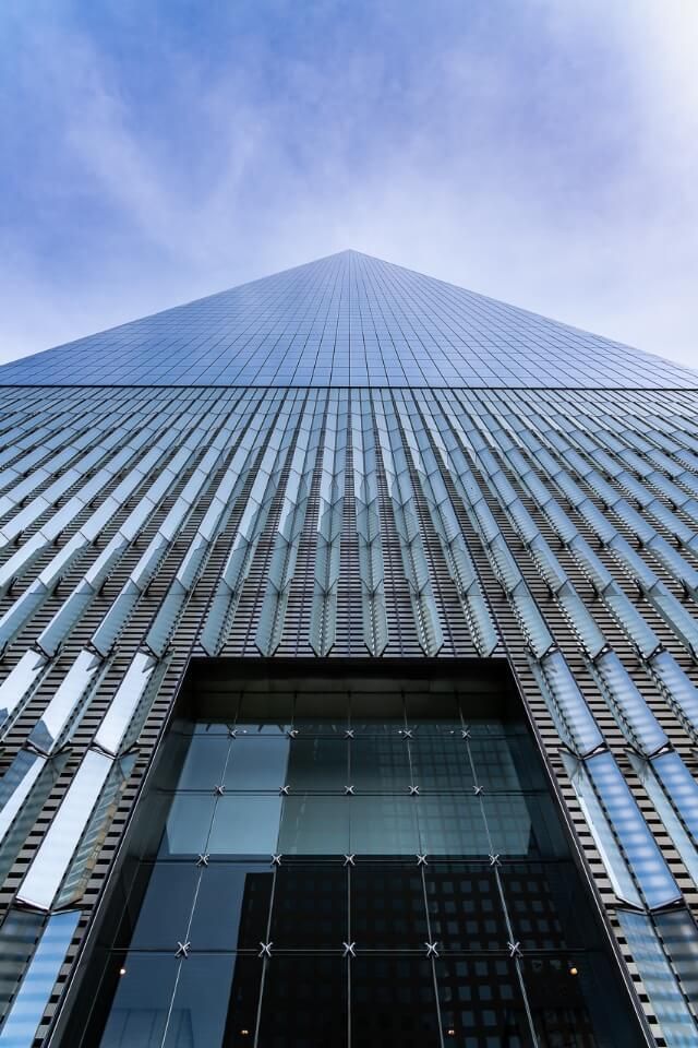 One world observatory at the world trade center towering above 9/11 memorial pool in new york city