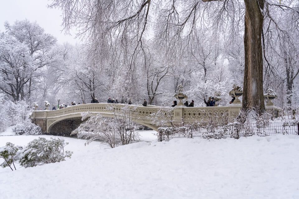 Central Park Bow Bridge in snow and ice winter plan a trip to nyc