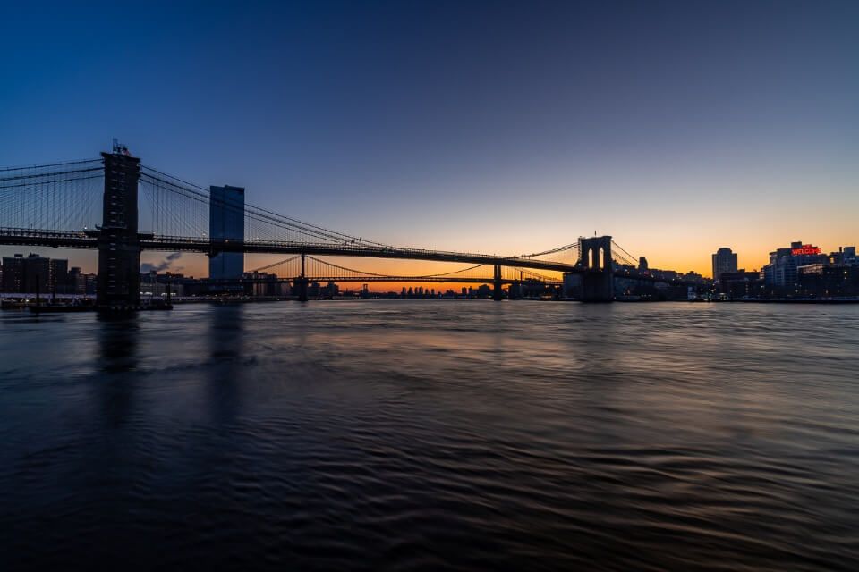 Brooklyn Bridge at sunrise taken from Pier 17 stunning colors in the sky one of the best hidden photography locations in NYC
