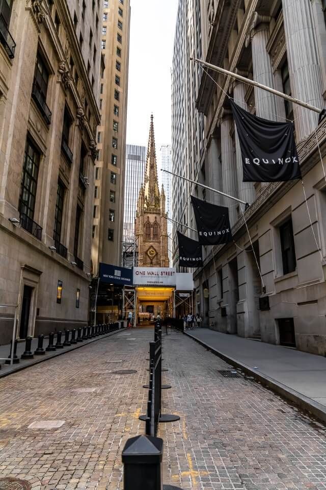Wall Street leading through the narrow buildings to Trinity Church
