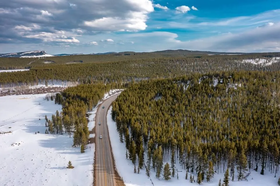 Cloud peak skyway scenic byway between Buffalo and ten sleep in wyoming drone shot of road with snow and trees