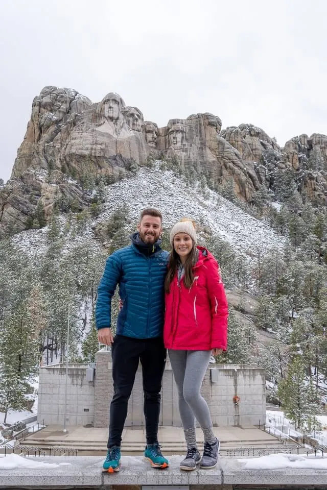 Onde estão os morgans de pé em frente do monte rushmore national memorial anfiteatro em um nublado dia de neve